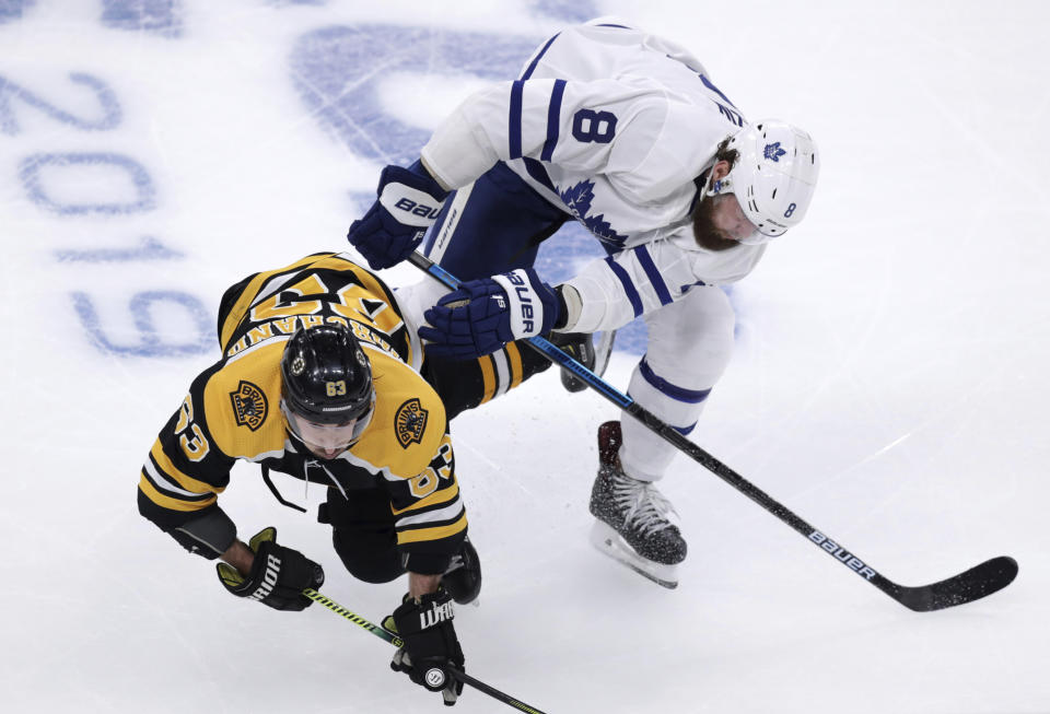 Boston Bruins left wing Brad Marchand (63) is knocked to the ice by Toronto Maple Leafs defenseman Jake Muzzin (8) during the first period of Game 7 of an NHL hockey first-round playoff series, Tuesday, April 23, 2019, in Boston. (AP Photo/Charles Krupa)