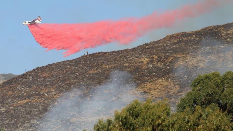 An air tanker drops retardant on a fire burning in the hills behind San Luis Obispo High School on Monday, Oct. 30, 2023.