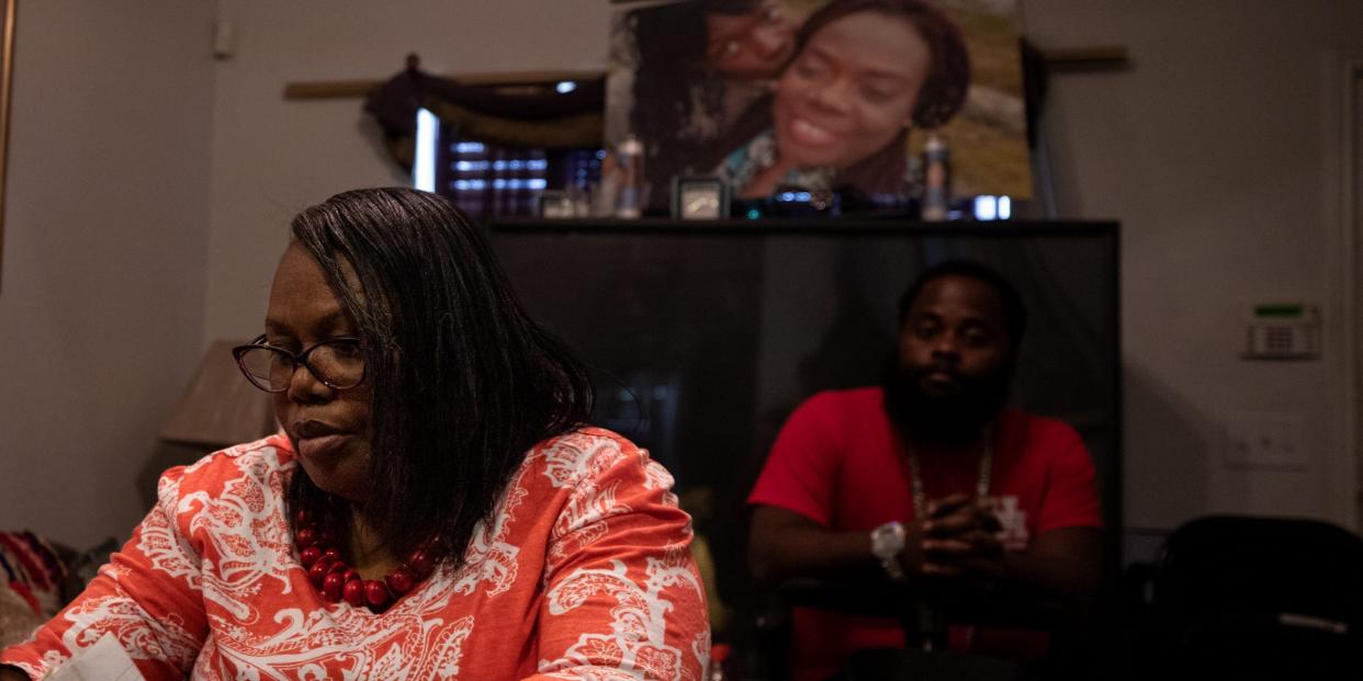 Joann McFadden with her daughter's  fiancé, Guy Hemphill Jr., beneath a photo of Kenne McFadden, her late daughter.