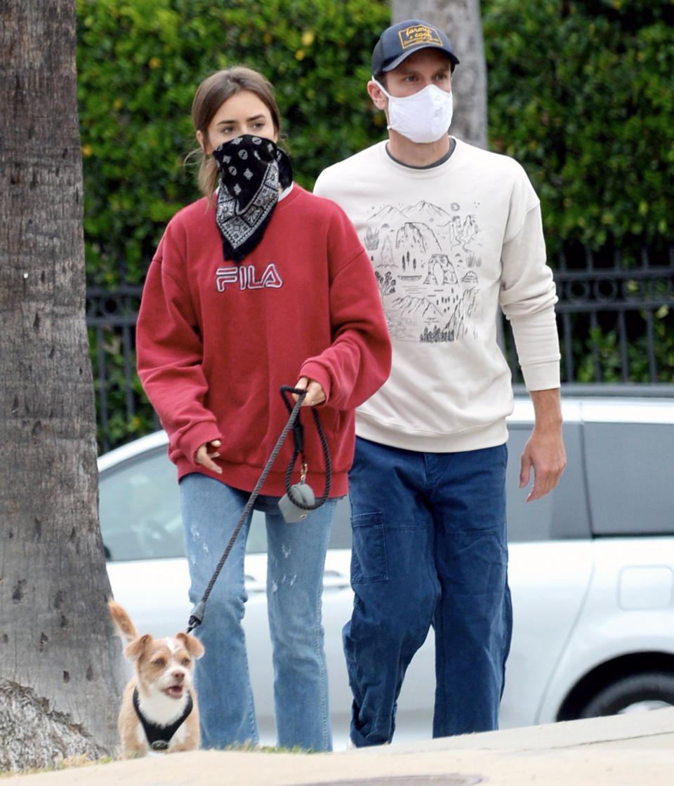 <p>Lily Collins and boyfriend Charlie McDowell take their dog for a walk in L.A. on Thursday.</p>