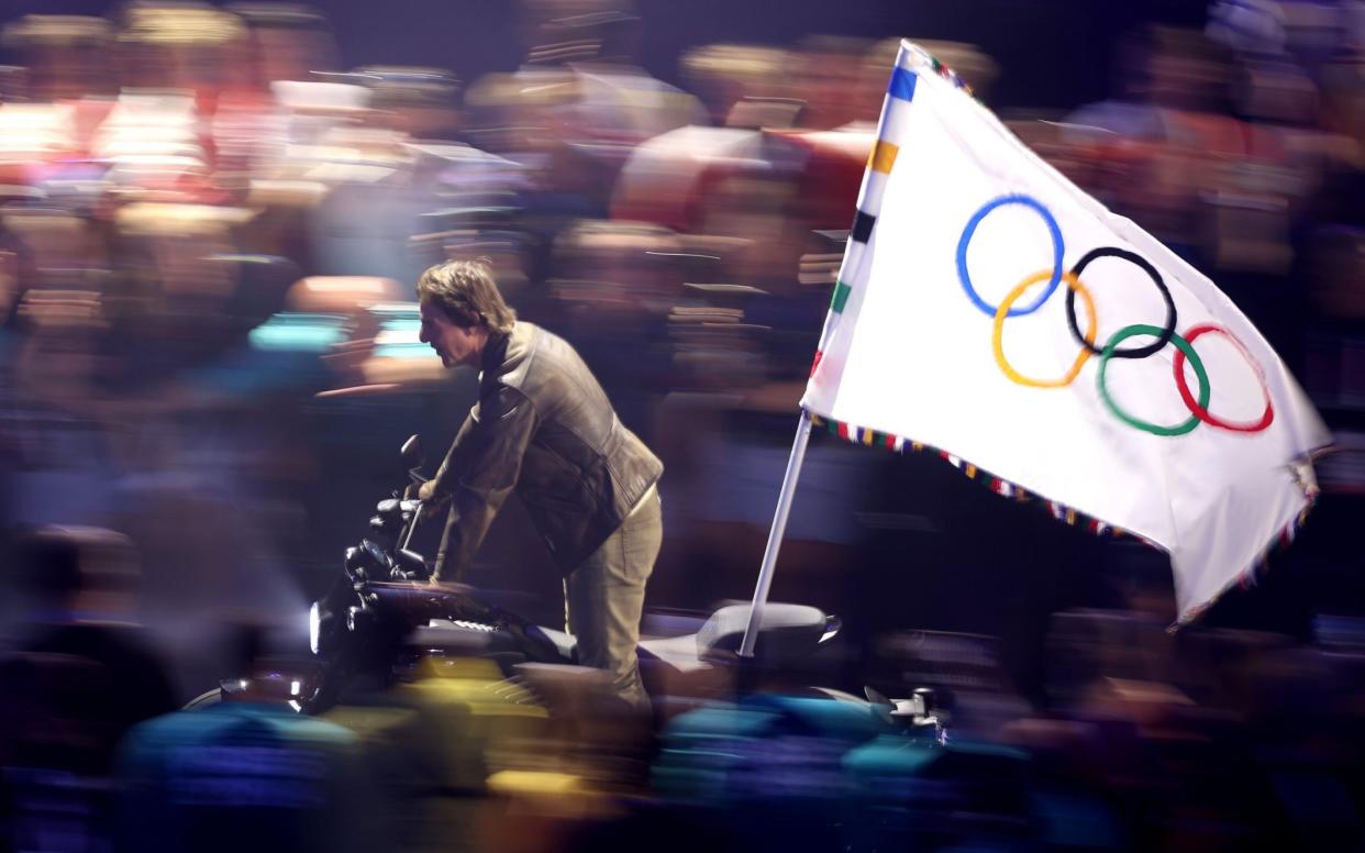 American Actor and Film Producer Tom Cruise rides on a Motorbike with the IOC Flag during the Closing Ceremony of the Olympic Games Paris 2024 at Stade de France on August 11, 2024 in Paris, France