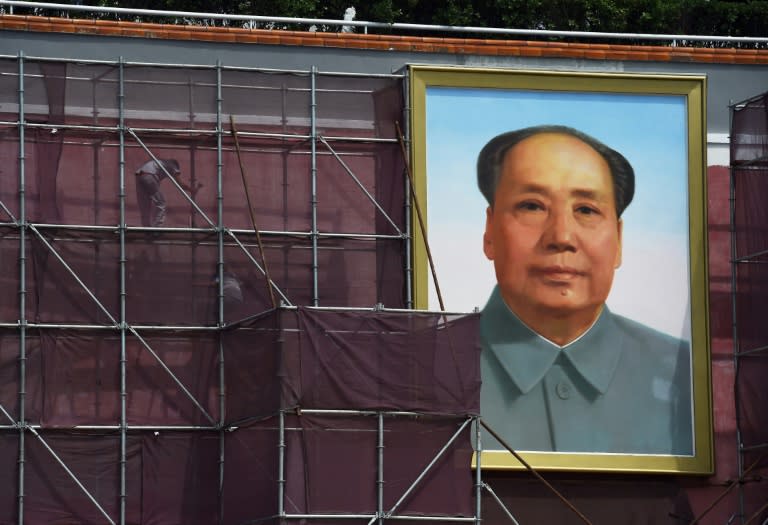 Workers pictured next to the giant portrait of late communist leader Mao Zedong in Beijing's Tiananmen Square on July 23, 2015