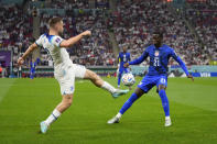 England's Luke Shaw, left, fights for the ball against Tim Weah of the United States during the World Cup group B soccer match between England and The United States, at the Al Bayt Stadium in Al Khor, Qatar, Friday, Nov. 25, 2022. (AP Photo/Julio Cortez)