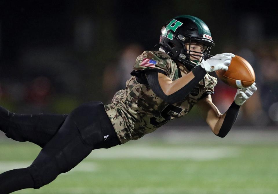 Highland wide receiver Kevin Heichel makes a diving catch for a first down during the second half of a football game against Barberton at Highland High School, Friday, Sept. 17, 2021, in Medina, Ohio.