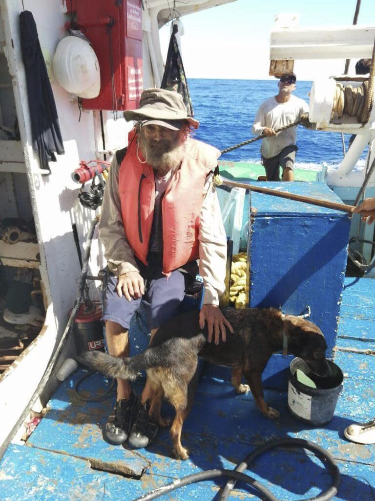 En esta fotografía proporcionada por Grupomar/Atun Tuny, el australiano Tim Shaddock permanece sentado con su perra Bella tras ser rescatado por un buque atunero mexicano en aguas internacionales del Pacífico, luego de que navegó a la deriva con Bella en su catamarán averiado durante tres meses. (Grupomar/Atun Tuny vía AP)