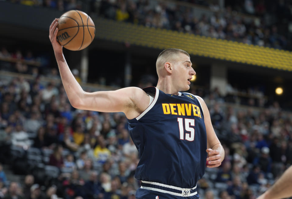 Denver Nuggets center Nikola Jokic looks to pass the ball after pulling in a rebound against the Brooklyn Nets in the first half of an NBA basketball game, Sunday, March 12, 2023, in Denver. (AP Photo/David Zalubowski)