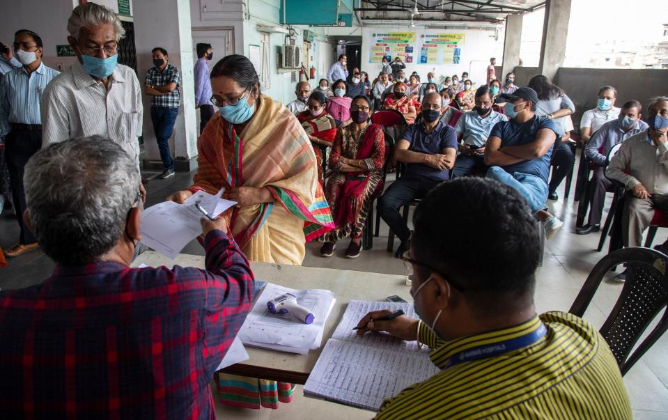 INDIA: Una anciana entrega un documento para registrarse para la vacuna COVID-19 en un hospital privado en Gauhati, India, el jueves 4 de marzo de 2021. Se inició la campaña de vacunación COVID-19 para personas mayores y mayores de 45 años con comorbilidades.