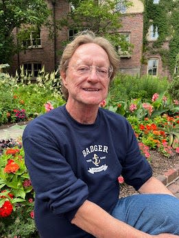 Chris Brethwaite sits outside the American Club during a visit with a friend.