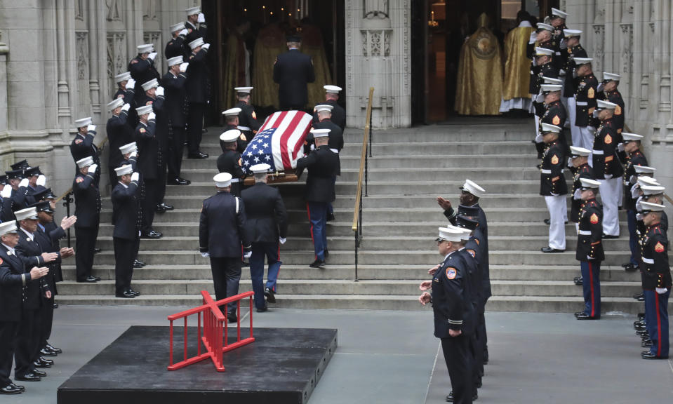The casket of U.S. Marine Corps Staff Sergeant and FDNY Firefighter Christopher Slutman, center, arrives for his funeral service at St. Thomas Episcopal Church, Friday April 26, 2019, in New York. The father of three died April 8 near Bagram Airfield U.S military base in Afghanistan. (AP Photo/Bebeto Matthews)