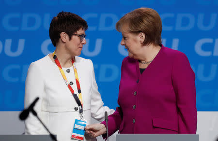 German Chancellor Angela Merkel talks to Annegret Kramp-Karrenbauer during a Christian Democratic Union (CDU) party congress in Berlin, Germany, February 26, 2018. REUTERS/Hannibal Hanschke