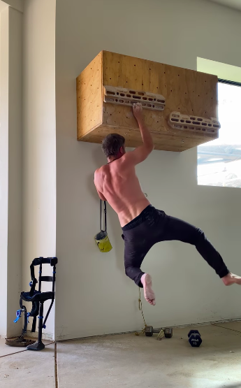 Rock climber Tommy Caldwell training on indoor climbing wall.