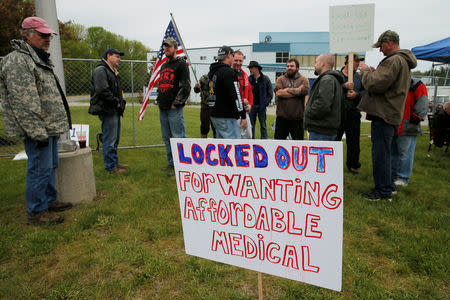 Locked-out members of the Local 651 International Brotherhood of Boilermakers union carry signs outside Westinghouse Electric's manufacturing facility in Newington, New Hampshire, U.S., May 22, 2017. REUTERS/Brian Snyder