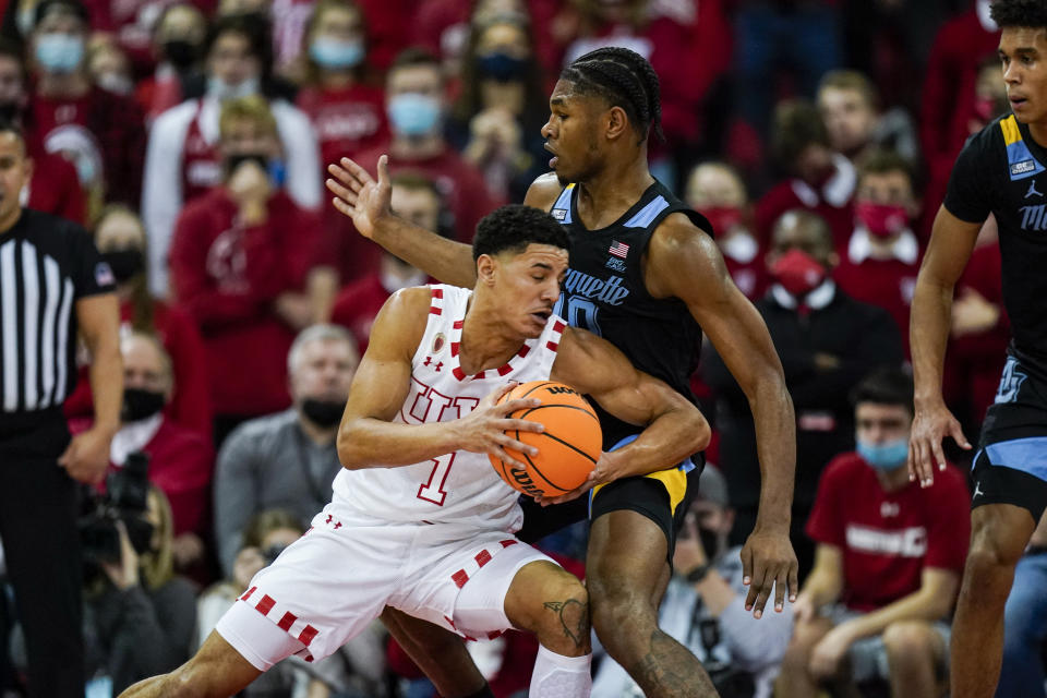 Wisconsin's Johnny Davis (1) drives against Marquette's Justin Lewis (10) during the first half of an NCAA college basketball game Saturday, Dec. 4, 2021, in Madison, Wis. (AP Photo/Andy Manis)