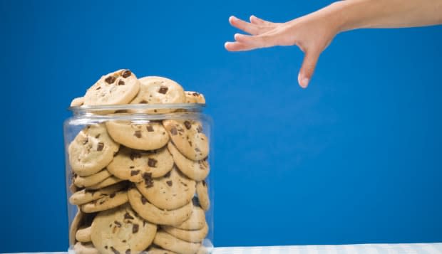 Hand reaching for chocolate chip cookie jar