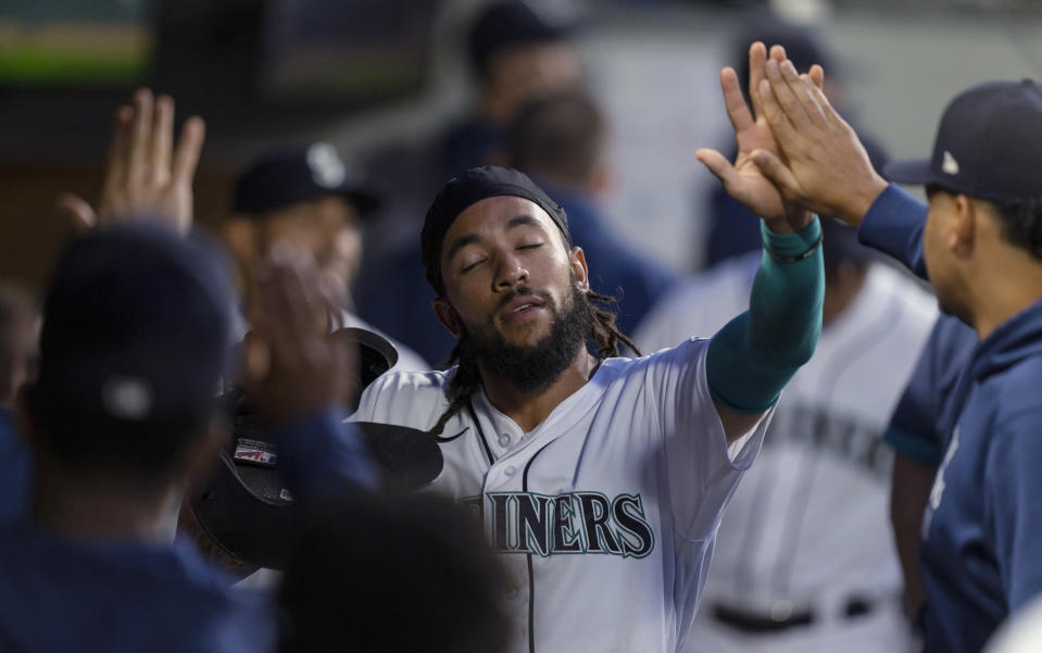 Seattle Mariners' J.P. Crawford celebrates in the dugout after scoring against the Minnesota Twins during the sixth inning of a baseball game Tuesday, June 15, 2021, in Seattle. (AP Photo/Stephen Brashear)