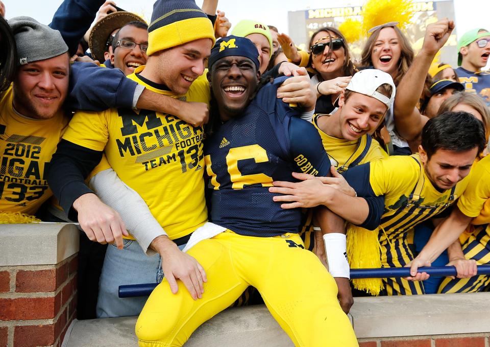 ANN ARBOR, MI - NOVEMBER 17: Denard Robinson #16 of the Michigan Wolverines celebrates a 42-17 victory over the Iowa Hawkeyes with fans at Michigan Stadium on November 17, 2012 in Ann Arbor, Michigan. (Photo by Gregory Shamus/Getty Images)