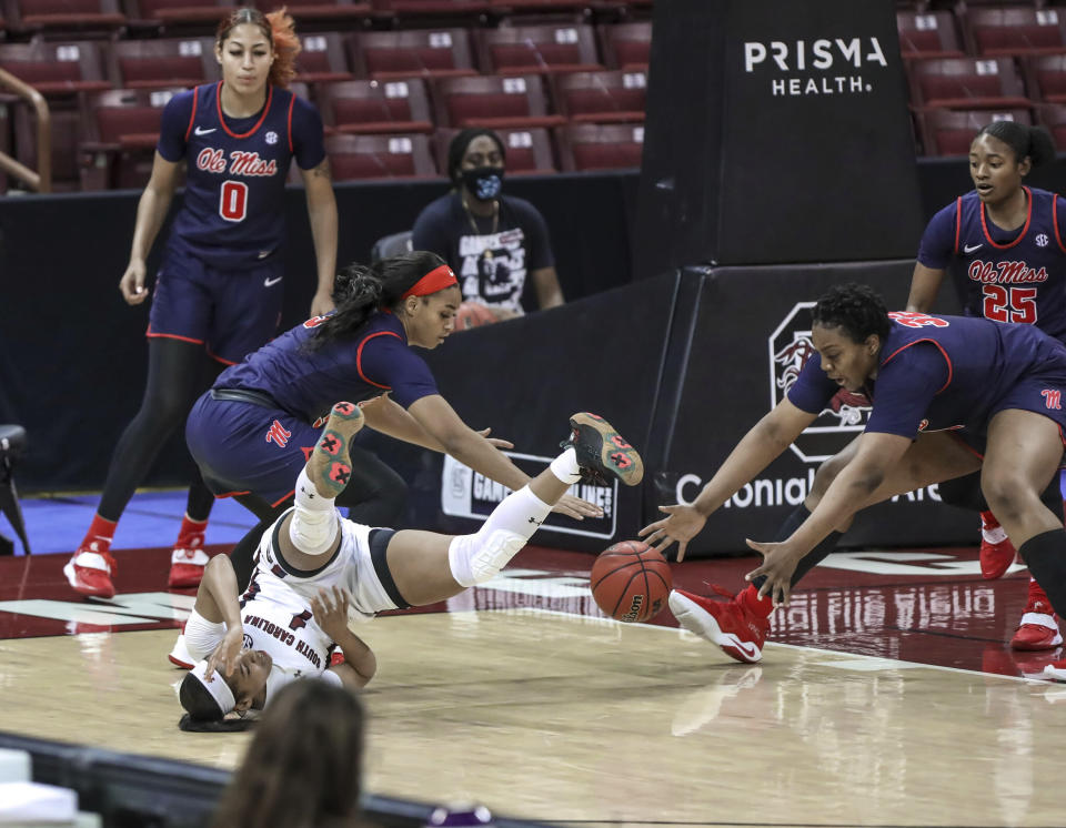 South Carolina guard Zia Cooke (1) falls as Mississippi guard Donnetta Johnson (3) and forward Iyanla Kitchens (32) go for a loose ball during the first half of an NCAA college basketball game in Columbia, S.C., Thursday, Feb. 25, 2021. (Tracy Glantz/The State via AP)