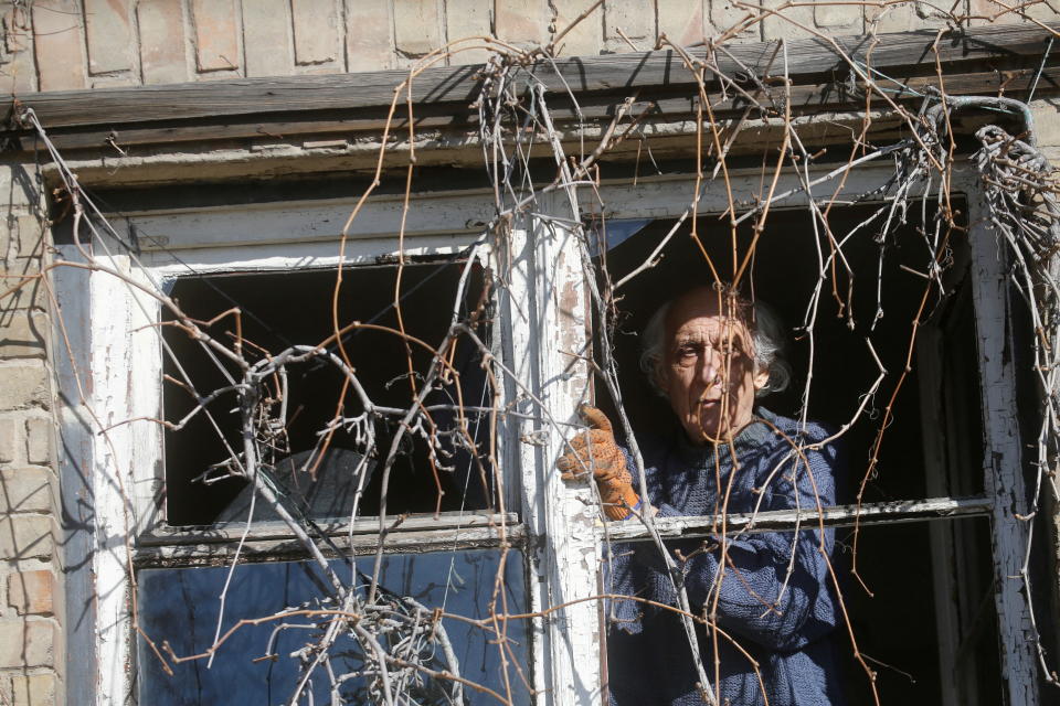 A man inspects a broken window, after Russia launched a massive military operation against Ukraine, in Kyiv.