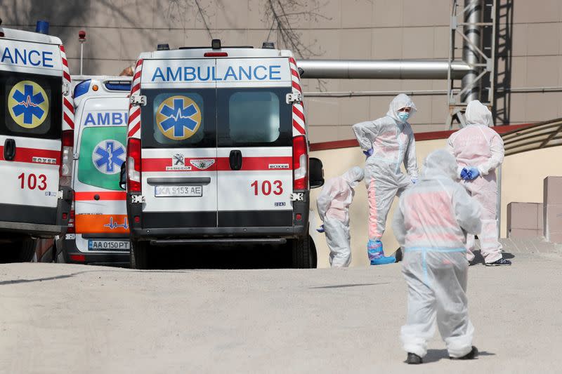 FILE PHOTO: Medical personnel stand next to ambulances with COVID-19 patients in Kyiv