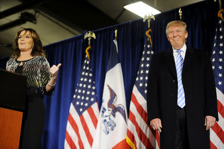 Former Alaska Gov. Sarah Palin (L) points to U.S. Republican presidential candidate Donald Trump (R) as she speaks after endorsing him for President at a rally at Iowa State University in Ames, Iowa January 19, 2016. REUTERS/Mark Kauzlarich/File Photo