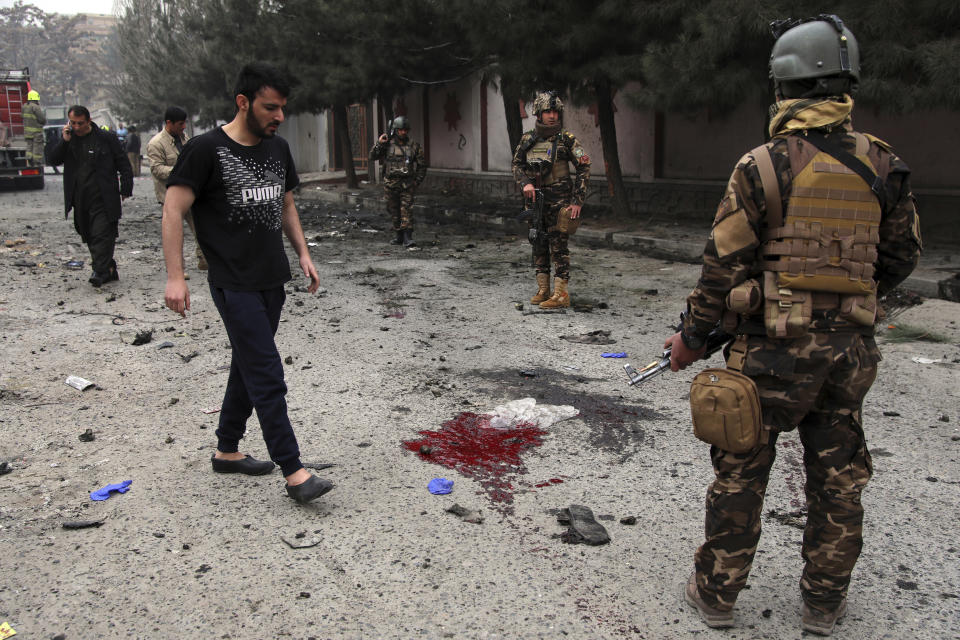 Security personnel inspect the site of a bomb attack in Kabul, Afghanistan, Saturday, Feb. 20, 2021. Three separate explosions in the capital Kabul on Saturday killed and wounded numerous people an Afghan official said. (AP Photo/Rahmat Gul)