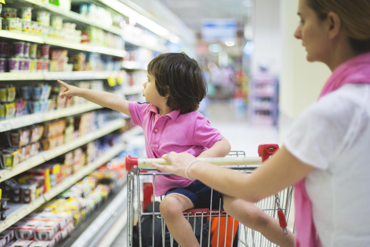 Woman with kid in supermarket trolley food shopping. (Getty Images)