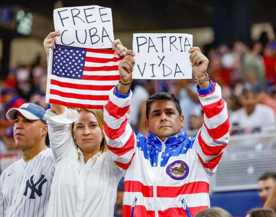 Baseball fans flash protest signs during the United States and Cuba game during the World Baseball Classic semifinal at loanDepot Park in Miami, Fla. on Sunday, March 19, 2023.