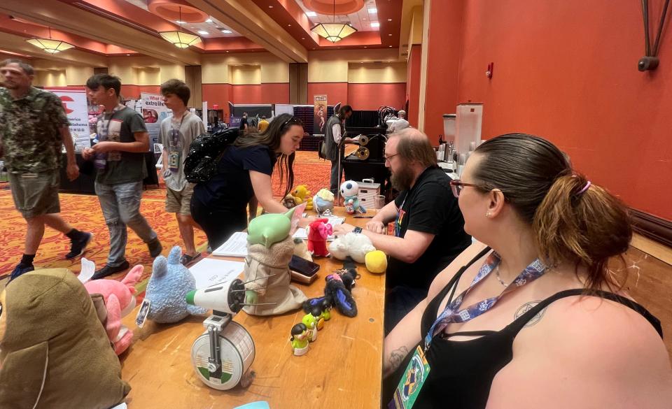 Madison Pierce, a volunteer with Nerding the Vote, watches as a young woman signs an initiative petition to raise the minimum wage at Soonercon, Oklahoma's indy pop culture convention. Piece and her friend, spent the weekend at the convention, seeking to register and encourage younger Oklahomans in voting.