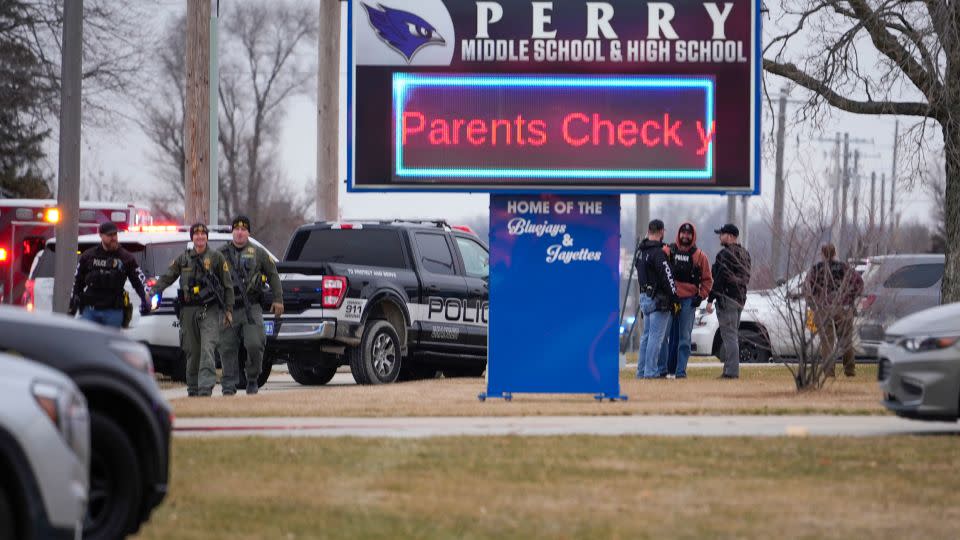 Law enforcement officers are seen outside Perry High School on Thursday. - Andrew Harnik/AP