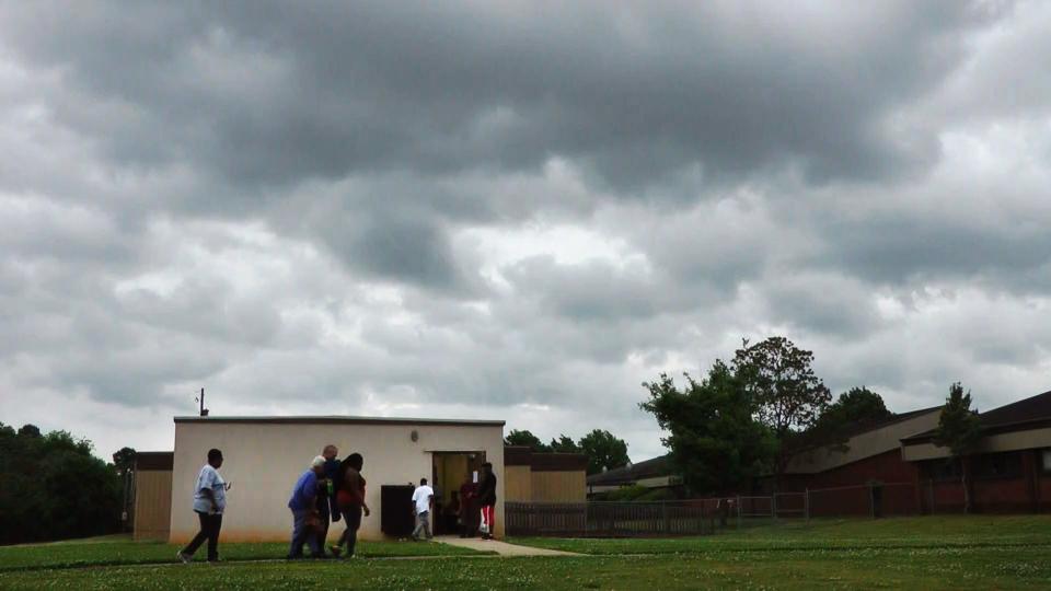 FILE- In this April 29, 2014 file image taken from video, people enter a community storm shelter during a tornado watch in Tuscaloosa, Ala. As each day brings the United States closer to peak severe weather season, Tornado Alley residents are facing a difficult question: Is it better to take on a twister outside a community shelter or to face the possibility of contracting the new coronavirus inside one? (AP Photo/Jay Reeves, File)