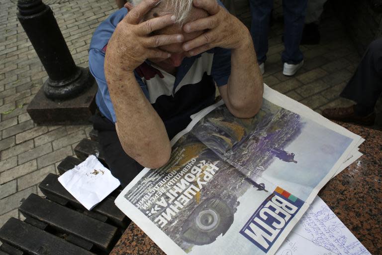 A man reads a newspaper with the front page depicting the plane crash of Malaysia Airlines flight MH17 in Kiev on July 18, 2014