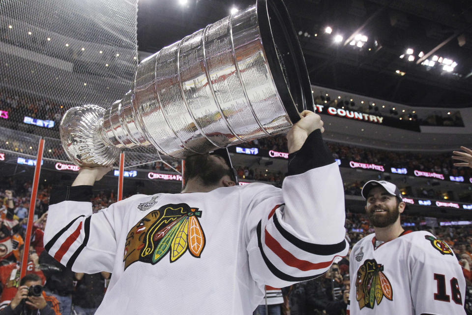 FILE - Chicago Blackhawks defenseman Brent Seabrook kisses the Stanley Cup after the Blackhawks beat the Philadelphia Flyers 4-3 in overtime in Game 6 of the NHL Stanley Cup hockey finals in Philadelphia, in this Wednesday, June 9, 2010, file photo. At right is Blackhawks' Andrew Ladd. Longtime Chicago Blackhawks defenseman and three-time Stanley Cup winner Brent Seabrook announced Friday, March 5, 2021, he’s unable to continue playing hockey because of injury. (AP Photo/Matt Slocum, File)