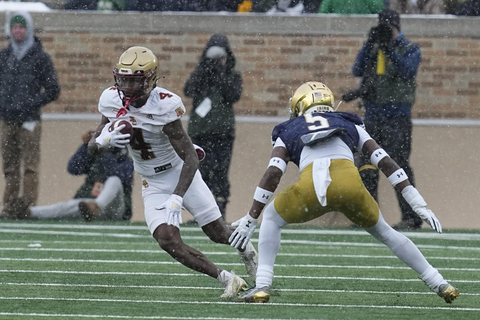 Boston College's Zay Flowers (4) runs against Notre Dame cornerback Cam Hart during the first half of an NCAA college football game, Saturday, Nov. 19, 2022, in South Bend, Ind. (AP Photo/Darron Cummings)