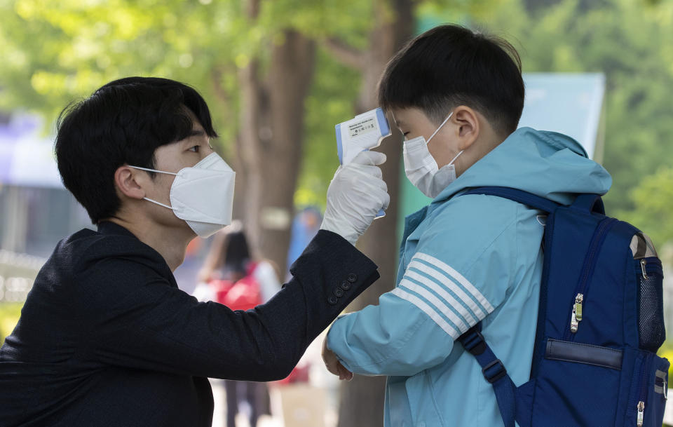 Image: A student gets body temperature measured when returning for classes at Seryun Elementary School in Seoul, South Korea (Lee Sang-ho/Xinhua / Getty Images file)