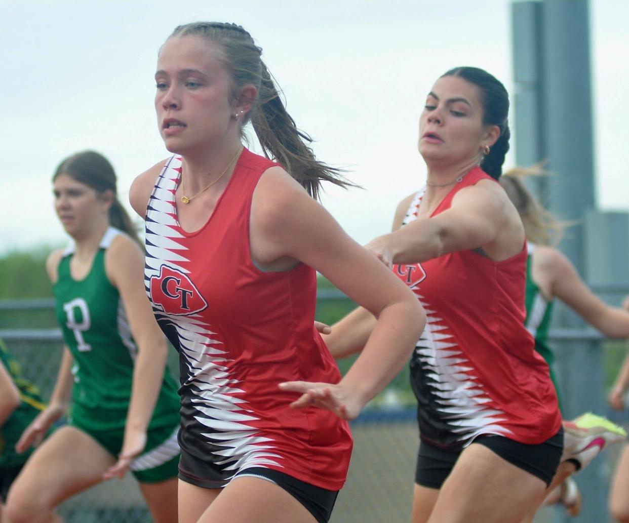 Conemaugh Township's Danika Black, left, reaches back to take the handoff from Ellie Speigle in the girls 4x100 relay at the Heritage Conference track and field championships, May 7, in Armagh.