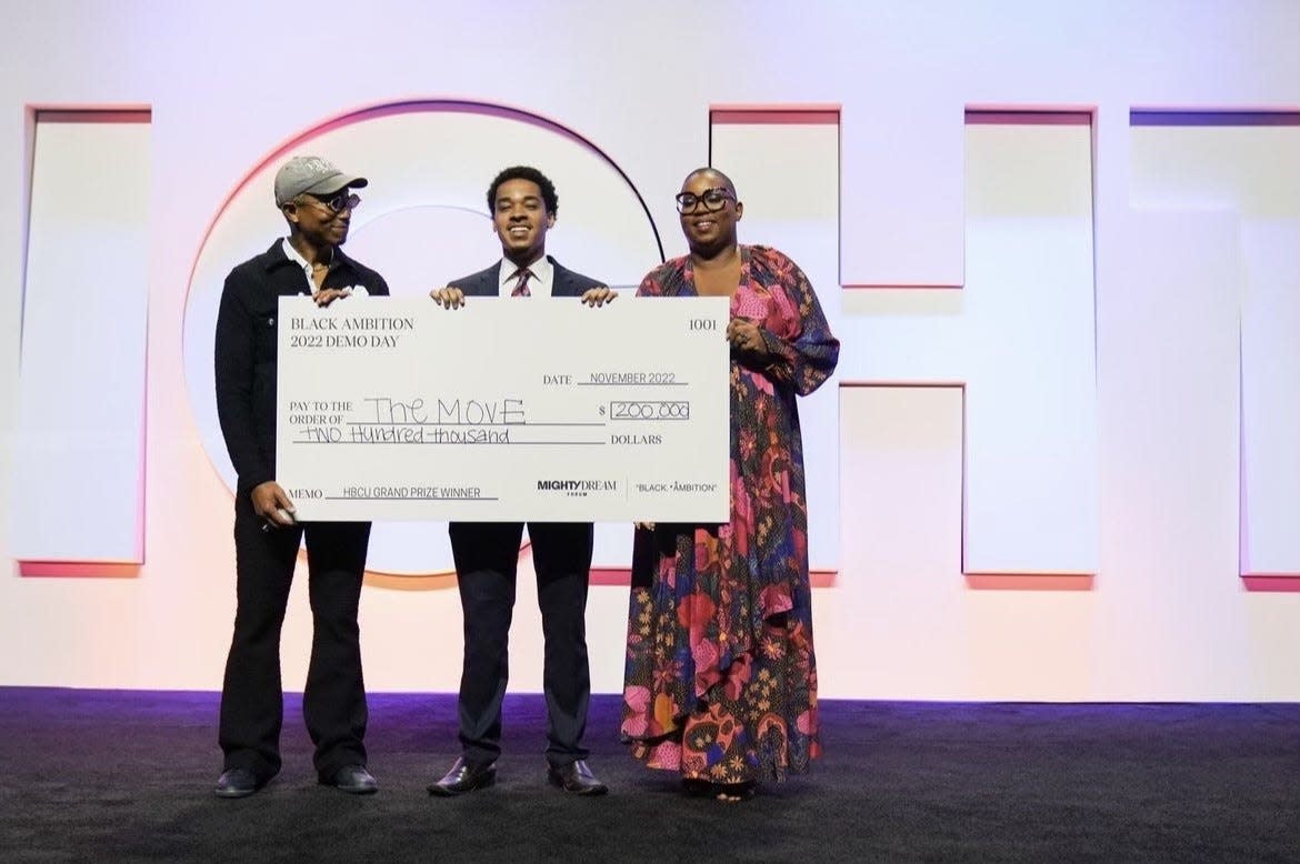 Zac Gilchrist (middle) pictured with $200,000 award from Black Ambition founder Pharrell Williams (left) and CEO Felecia Hatcher.