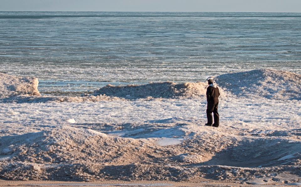 Jace Seavers, of Manitowoc, takes in the ice-crusted lakefront near the Mariners Trail, Friday, January 21, 2022, in Manitowoc, Wis. Seavers recently moved back to the area after spending time on the west coast.