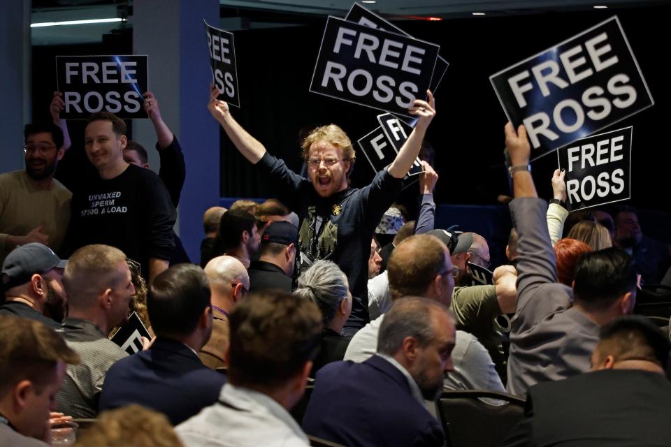 Members of the Libertarian Party stand in chairs while chanting and demanding the release of Ross Ulbricht during the party's national convention