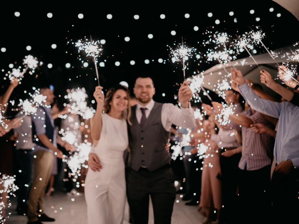 a bride and groom leaving their wedding with a sparkler exit