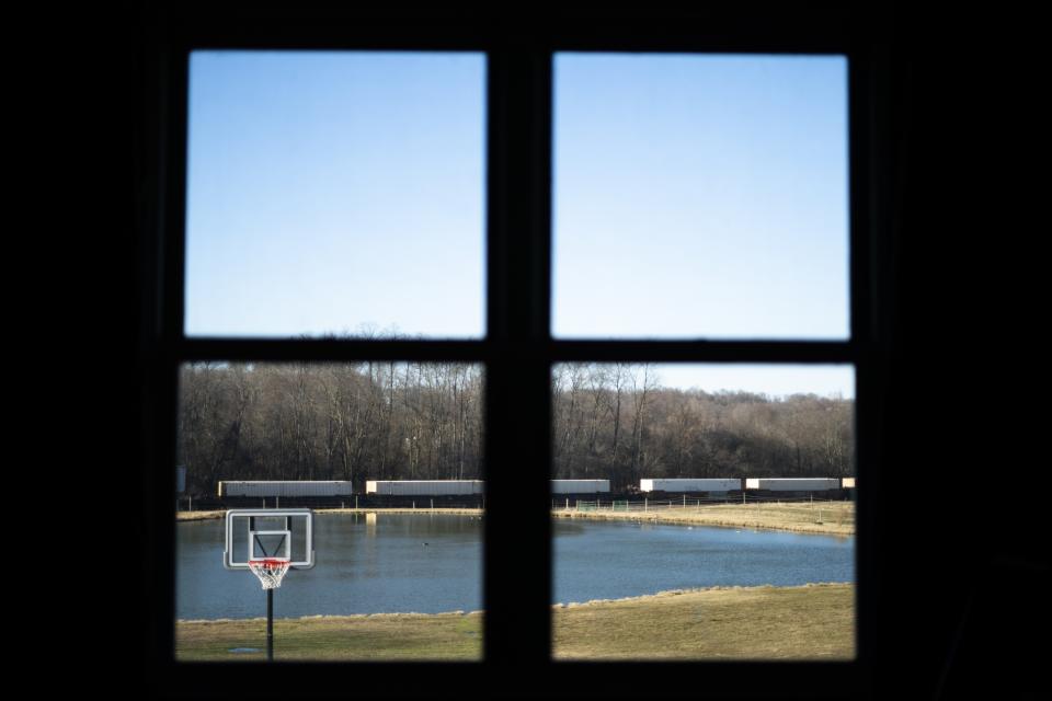A train passes in view of Jessica Conard's window at her home in East Palestine, Ohio, Tuesday, March 7, 2023. She wonders after the train derailment if her kids will ever be able to fish in the pond separating their property from the railroad tracks. Or play at the park where the chemicals are being removed from a stream. Can they remain in the town where "generations upon generations" of family have lived? (AP Photo/Matt Rourke)