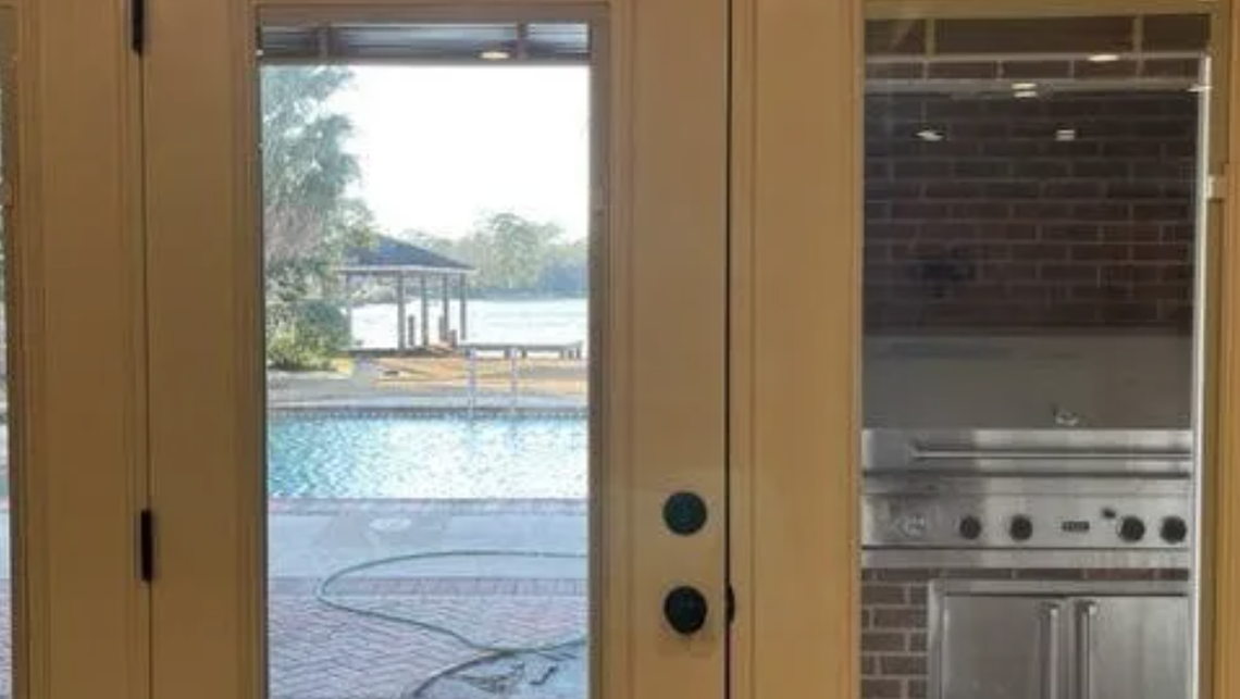 A heated saltwater pool is located between the house and Lake Katherine.