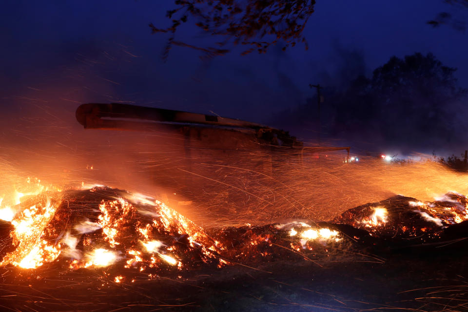 Embers fly around a burnt out truck during the wind-driven Kincade Fire in Healdsburg, California, U.S. October 27, 2019. REUTERS/Stephen Lam