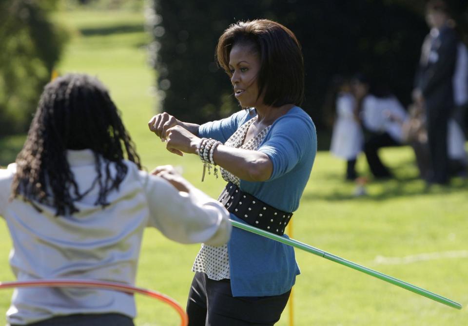FILE - In this Oct. 21, 2009 file photo, first lady Michelle Obama exercises with a hula hoop during a healthy kids fair on the South Lawn of the White House in Washington. What does Michelle Obama do next? After eight years as a high-profile advocate against childhood obesity, a sought-after talk show guest, a Democratic power player and a style maven, the first lady will have her pick of options when she leaves the White House next month. (AP Photo/Haraz N. Ghanbari, File)