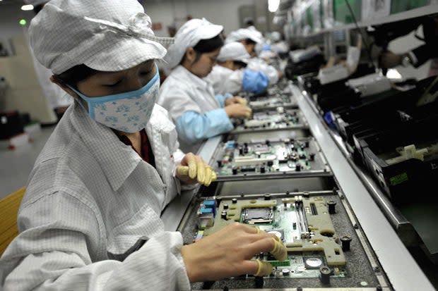 p81 In a picture taken on May 26, 2010 Chinese workers assemble electronic components at the Taiwanese technology giant Foxconn's factory in Shenzhen, in the southern Guangzhou province. Foxconn on June 2 confirmed the death of another employee but denied he died of exhaustion following a spate of suicides at its Chinese plants. CHINA OUT AFP PHOTO (Getty)
