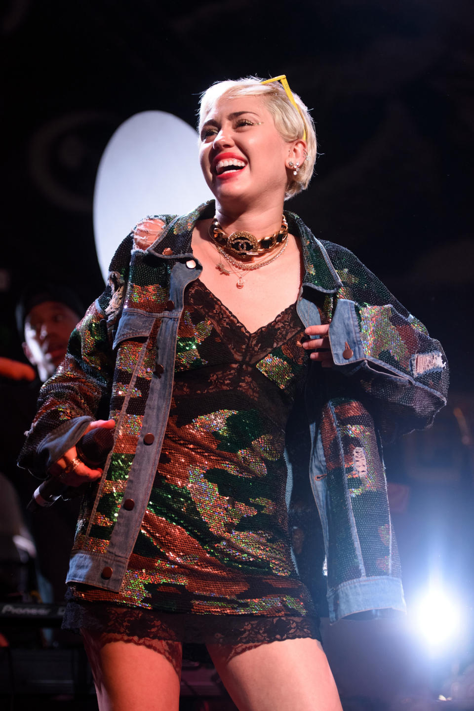 Cyrus surprised festival goers by getting onstage with Mike WiLL Made-It wearing a camouflage sequin slip with matching denim jacket and Chanel choker.