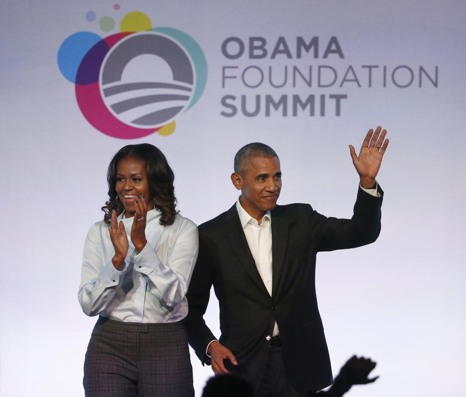 FILE - In this Oct. 13, 2017 file photo, former President Barack Obama, right, and former first lady Michelle Obama arrive for the first session of the Obama Foundation Summit in Chicago. A documentary about an Ohio auto glass factory that is run by a Chinese investor debuted Wednesday, Aug. 21, 2019, on Netflix, as the streaming service's first project backed by Michelle and Barack Obama's new production company. (AP Photo/Charles Rex Arbogast, File)