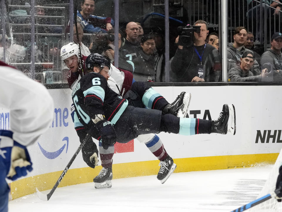 Seattle Kraken defenseman Adam Larsson (6) flies in the air as he battles Colorado Avalanche right wing Logan O'Connor (25) during the second period of Game 4 of an NHL hockey Stanley Cup first-round playoff series, Monday, April 24, 2023, in Seattle. (AP Photo/Lindsey Wasson)