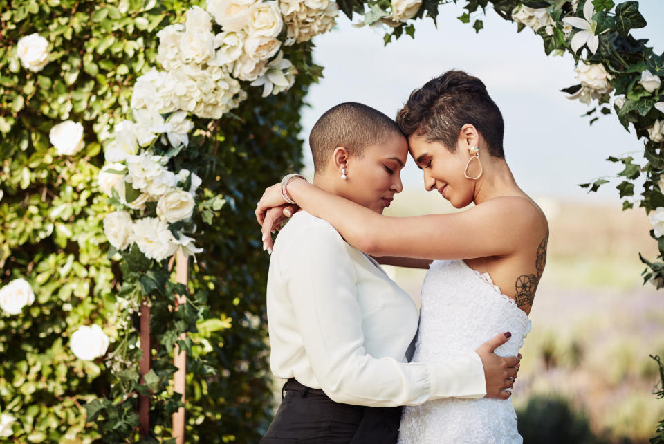 Two women embrace on their wedding day