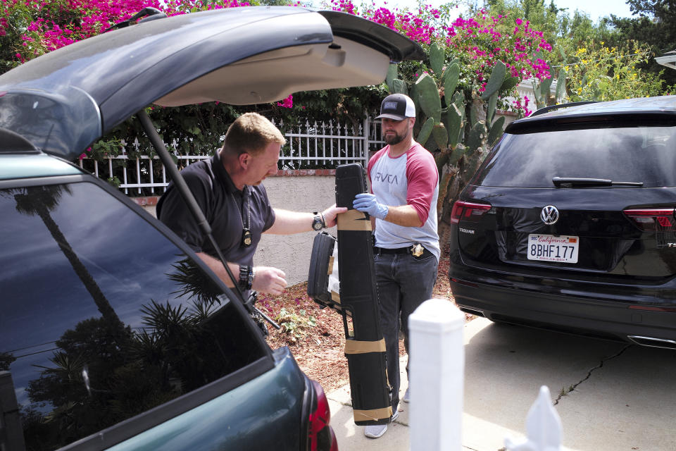 FBI agents remove evidence from the home of Robert Chain in the Encino section of Los Angeles on Thursday, Aug. 30, 2018. Chain, who was upset about The Boston Globe's coordinated editorial response to President Donald Trump's attacks on the news media, was arrested Thursday for threatening to travel to the newspaper's offices and kill journalists, whom he called the "enemy of the people," federal prosecutors said. (David Crane/Los Angeles Daily News via AP)