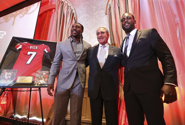 Atlanta Falcons owner Arthur Blank, center, honors former Falcons quarterback Michael Vick, right, and wide receiver Roddy White as they officially retire from the NFL on Monday. (Atlanta Journal-Constitution via AP)